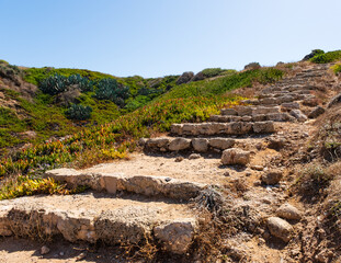 Fototapeta na wymiar An ancient stone staircase on a green hill