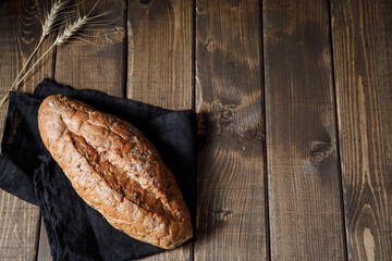 Homemade crusty loave of wholemeal bread on wooden background