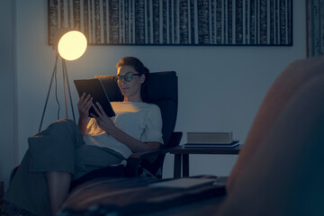 Woman relaxing in the living room and connecting with her tablet