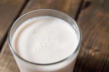 Probiotic cold fermented dairy drink kefir on wooden background.