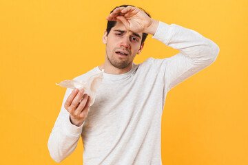 Photo of sick unhappy man with runny nose posing with tissue on camera