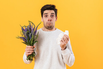 Photo of handsome unhappy man with allergy posing with flowers - obrazy, fototapety, plakaty