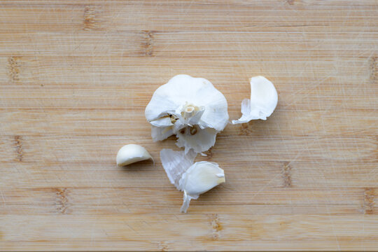 Fresh garlic bulb with loose cloves on wood