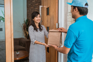 Delivery man delivering food to a woman at home. online food shopping service concept