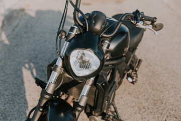 detalle frontal de motocicleta estacionada sobre asfalto en exterior con luz natural