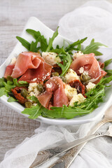 Arugula salad, prosciutto with sun-dried tomatoes