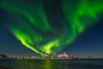 Dramatic aurora borealis, polar lights, over mountains in the North of Europe - Lofoten islands, Norway