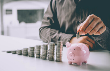 Man putting coin in piggy bank. saving money, budget, investment, finance concept