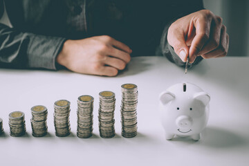 Man putting coin in piggy bank. saving money, budget, investment, finance concept