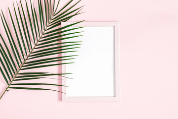 Summer composition. Tropical leaves, photo frame on pink background. Summer concept. Flat lay, top view, copy space