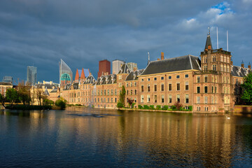 Obraz premium View of the Binnenhof House of Parliament and the Hofvijver lake with downtown skyscrapers in background. The Hague, Netherlands