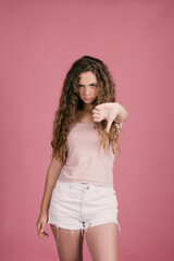 beautiful girl with long curly hair, surprised and unhappy with her damaged hair