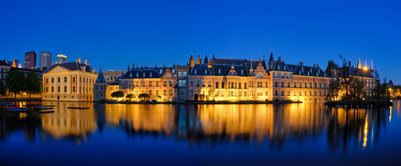 Panorama of the Binnenhof House of Parliament and Mauritshuis museum and the Hofvijver lake illuminated in the night. The Hague, Netherlands