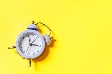 Simply minimal design ringing twin bell vintage classic alarm clock Isolated on yellow background....