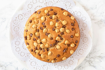 A round beautiful hazelnut and chocolate chips cake from above.