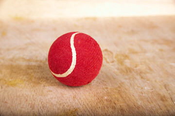 red tennis ball on a wooden table