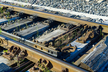 Railroad closeup. Railway tracks, Iron rusty train railway detail over dark stones.