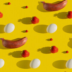 A seamless texture that depicts a banana, egg, strawberry on a yellow background. View from above. The apartment was lying.