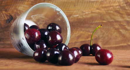  ripe cherries in a glass on a wooden background           