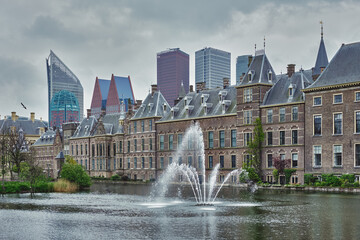 Fototapeta na wymiar View of the Binnenhof House of Parliament and the Hofvijver lake with downtown skyscrapers in background. The Hague, Netherlands