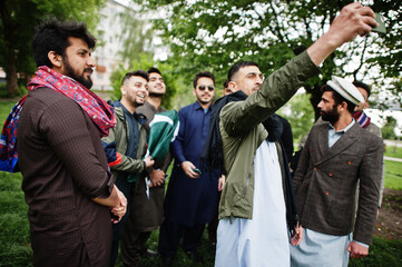 Group of pakistani man wearing traditional clothes salwar kameez or kurta making selfie on mobile phone.