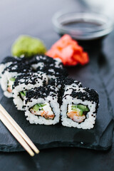 Sushi roll with black caviar on a slate plate