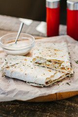 pita bread with cheese and sauce on a wooden background in cafe
