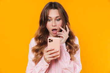 Image of shocked woman expressing surprise and using mobile phone