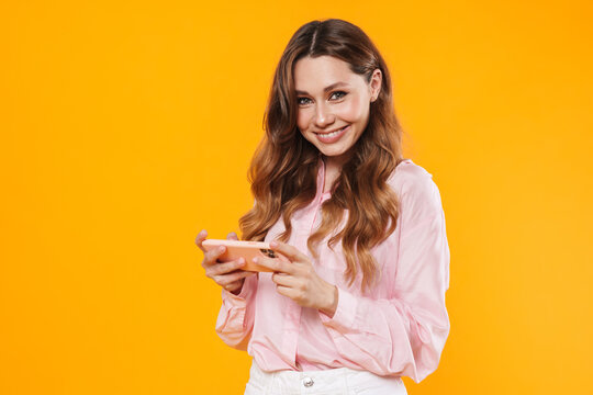 Image of beautiful pleased woman smiling and using mobile phone
