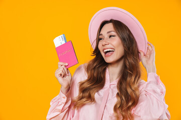 Image of cheerful woman holding passport with ticket and laughing