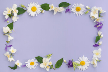 Floral composition. Frame made of various colorful flowers on purple background. Easter, spring, summer concept. Flat lay, top view, copy space for text.