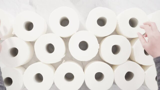Flat lay. New white toilet paper rolls on a gray background.