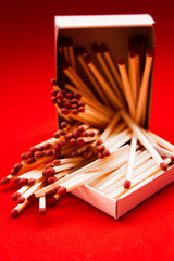Scattered on a pile of wooden matches with matches on a red background