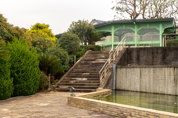 Old, european colonial style house painted green among the trees in Glover Garden in Nagasaki, Japan.