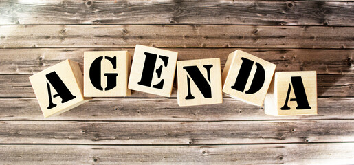 Agenda - words made of wooden blocks with letters, list of questions on the agenda concept, wooden background