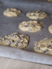 Selective focus close up shot of raw homemade cookies on baking paper.