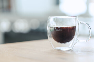 Closeup glass of hot americano coffee on wood table, selective focus, vintage tone