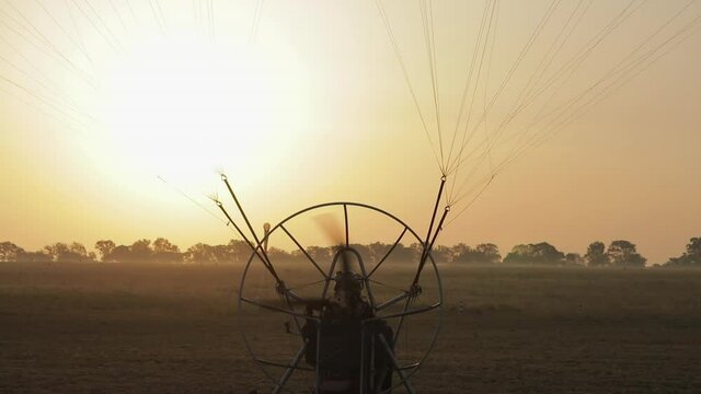 Para motor takes off, sunrise landscape with sunbeams