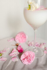 Glass with milk and roses on the table