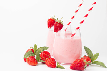 Glass of fresh strawberry milkshake, smoothie and fresh strawberries on pink, white and wooden background. Healthy food and drink concept.