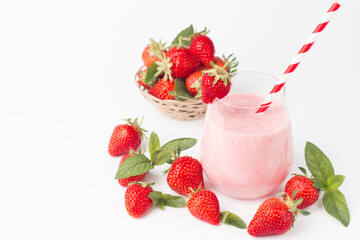 Glass of fresh strawberry milkshake, smoothie and fresh strawberries on pink, white and wooden background. Healthy food and drink concept.