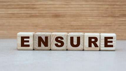 concept of the word ENSURE on cubes on a wooden background