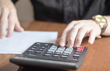 Financial data analyzing hand writing and counting on calculator