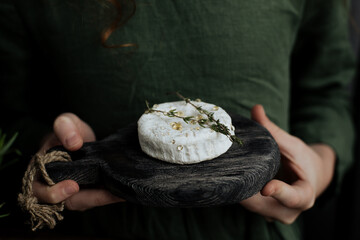 Camembert cheese head on a wooden cutting board