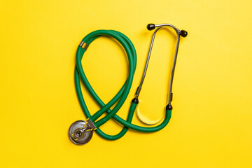 Top view of green stethoscope on colorful background. Medical diagnosis tool concept