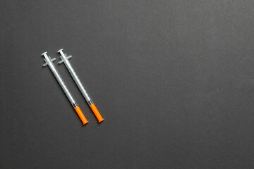 Top view of two insulin syringe at colorful background with copy space. High level of glucose concept
