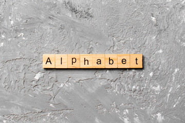 alphabet word written on wood block. alphabet text on cement table for your desing, concept