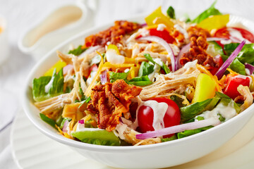 chicken club salad in a white bowl