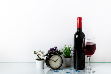 Alarm Clock, green houseplant, red wine and coffe on a white background. The concept of a healthy lifestyle, sport, diet. The concept of time is precious. Home decor with copy space for your text.