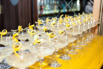 a large number of cocktails decorated with lemon zest